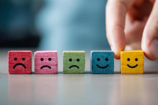Colorful wooden blocks displaying varying emotions from sad to happy, symbolizing customer satisfaction and emotional progression in decision making processes photo