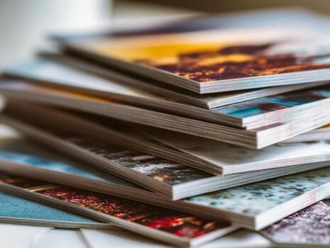 A stack of colorful magazines with glossy covers arranged in a slightly tilted pile showcasing vibrant images and varied textures on each page edge photo
