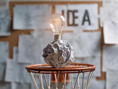 Creative idea concept with a lightbulb on crumpled paper in a brainstorming setting photo