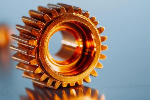 Detailed view of a shiny metallic copper gear with interlocking teeth reflecting on a smooth surface, highlighting precision engineering and mechanical design concepts photo