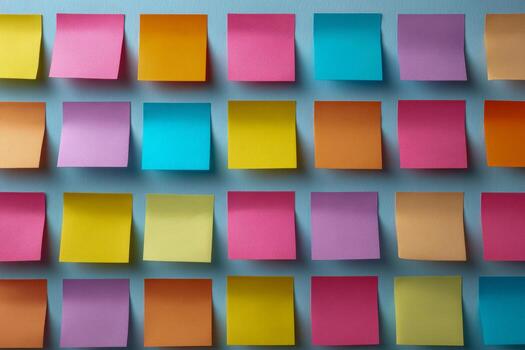 Colorful sticky notes arranged in a grid pattern on a light blue background for organization and brainstorming ideas in office or creative spaces photo