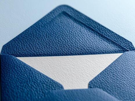 Textured blue envelope partially open revealing white paper inside with focus on the detailed grain pattern and elegant design photo