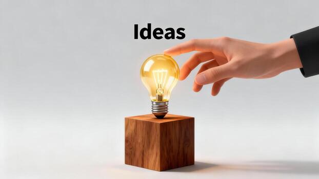 A hand reaches towards a glowing light bulb resting on a wooden block, signifying new ideas. photo