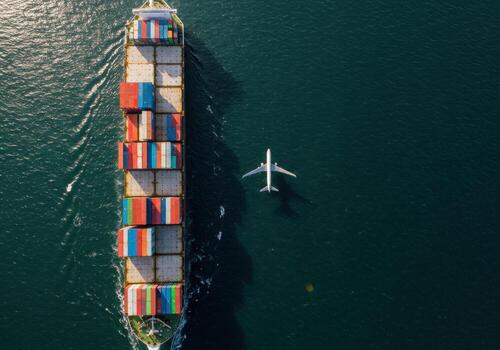 Massive cargo ship navigates deep blue sea alongside a soaring airplane, symbolizing global logistics and interconnected transportation networks photo