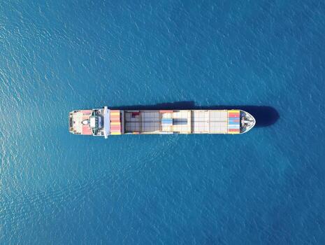 Majestic cargo ship navigates vast ocean expanse, delivering global commerce with vibrant container loads under bright sunlight photo