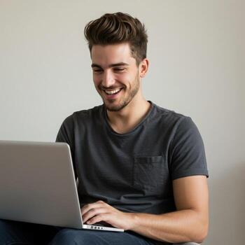Young man happily working on laptop, smiling with joy and engagement, embracing modern technology and remote work lifestyle photo