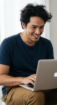 Joyful man laughing while typing on a laptop, embracing modern technology and casual work. photo