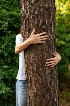 Hands hugging a tree, unity with nature. photo