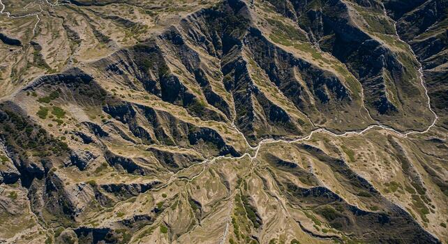 Aerial View of Rugged Mountain Range with Varied Terrain and Natural Patterns. photo