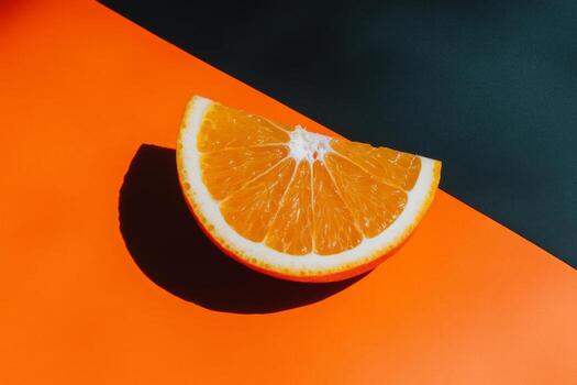 Vibrant Orange Slice on Contrasting Background with Dramatic Shadow photo