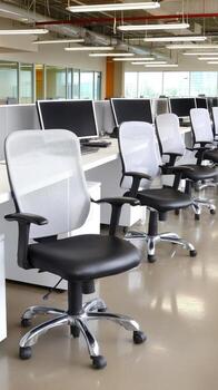 Office workspace with modern desk chairs and computers during daytime, showcasing a clean and organized work environment photo