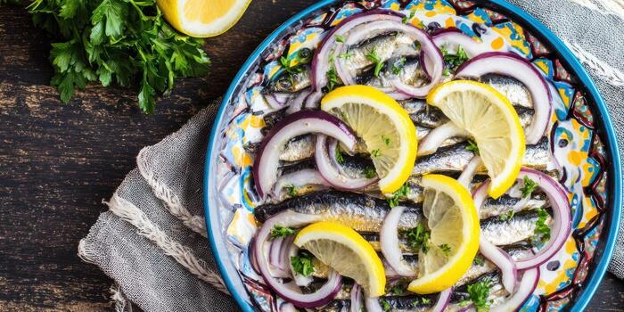 Overhead view of seafood dish with lemon red onion and parsley on a plate photo