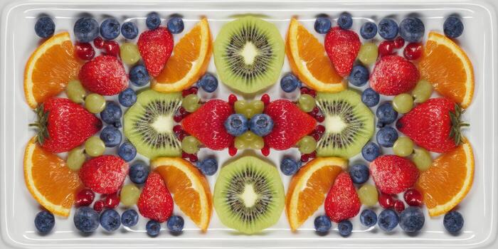 Arrangement of fresh fruit slices in symmetrical composition on white plate photo
