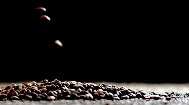 Close up of coffee beans falling against a dark background copy space photo