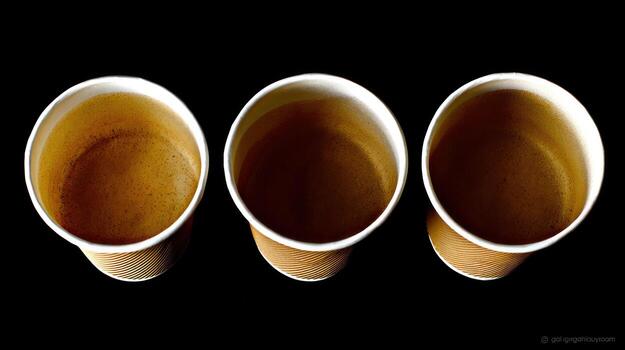 Three paper cups in overhead view against black background photo
