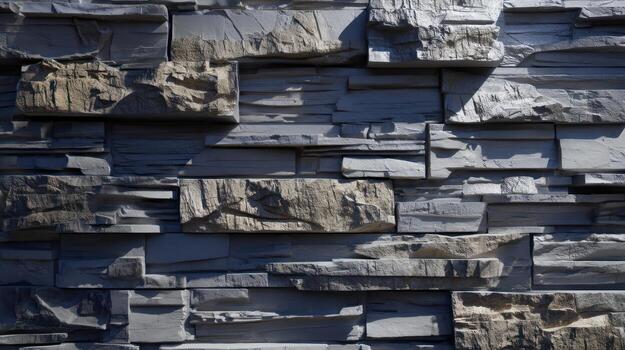 Close up view of a textured stone wall with varying shades and shadows photo