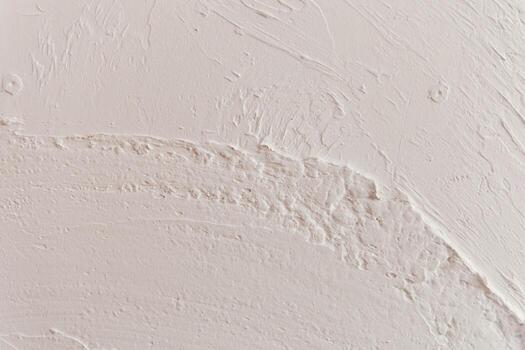 Surface texture of plastered wall showing irregular patterns and smooth areas in soft light photo