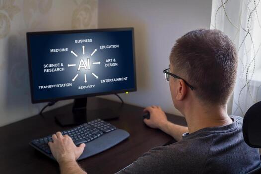 Remote work from home. Man focused on computer screen displaying various AI concepts in contemporary workspace, technology impact on different fields like education, business and entertainment photo