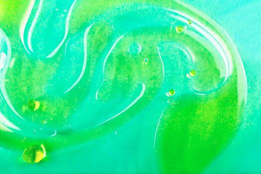 Water background with oil stains. Vivid green abstract liquid texture showcases swirling patterns and glossy droplets on smooth surface, creating captivating visual effect photo