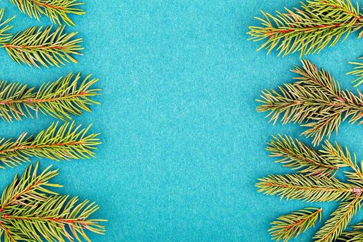 Christmas. New Year. Green pine branches are beautifully arranged around vibrant blue background, creating fresh and natural frame with ample copy space for text or design elements photo