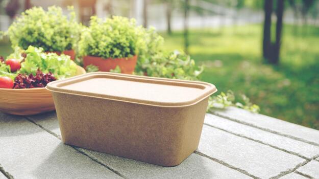 eco simpático comida envase con ensalada en de madera mesa al aire libre ajuste foto