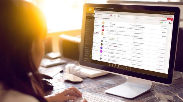 Woman working on computer at desk indoors bright sunlight photo