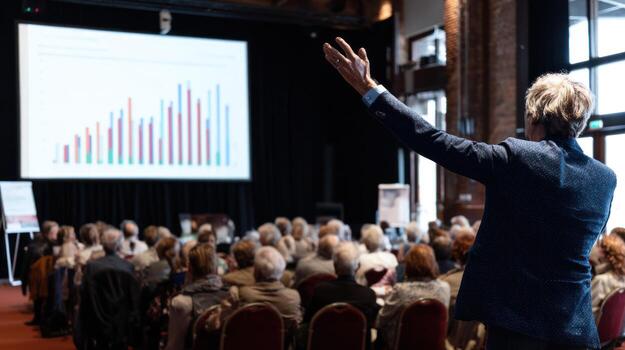 Presenter addressing audience with chart on screen during business conference photo