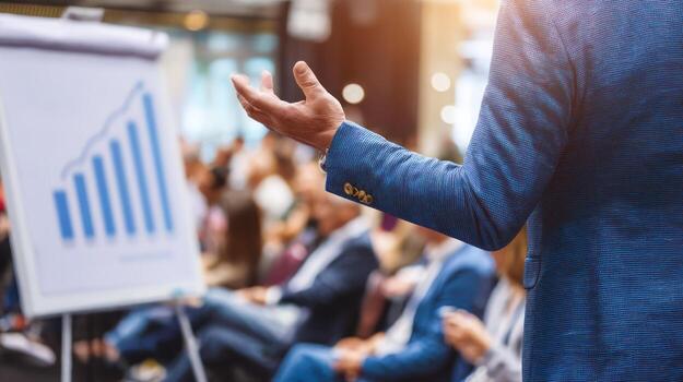 Presenter gesturing during a business meeting with chart and audience photo