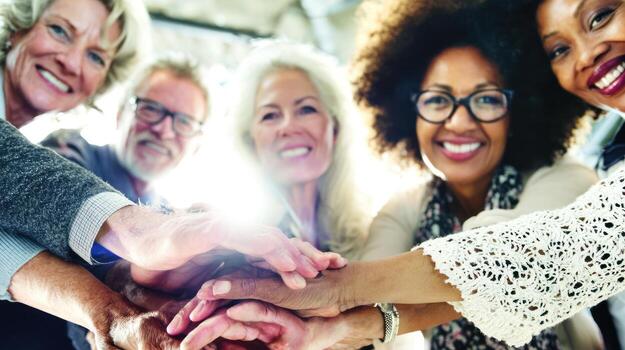 Diverse group of people putting hands together for teamwork and unity photo