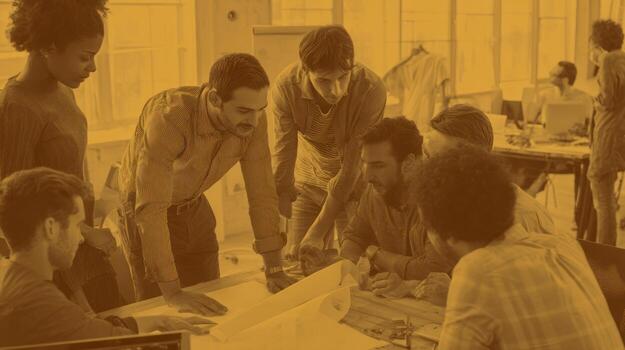 Group of colleagues collaborating over a project indoors in warm lighting photo