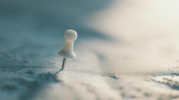Close up of a white push pin on a blurred paper map photo