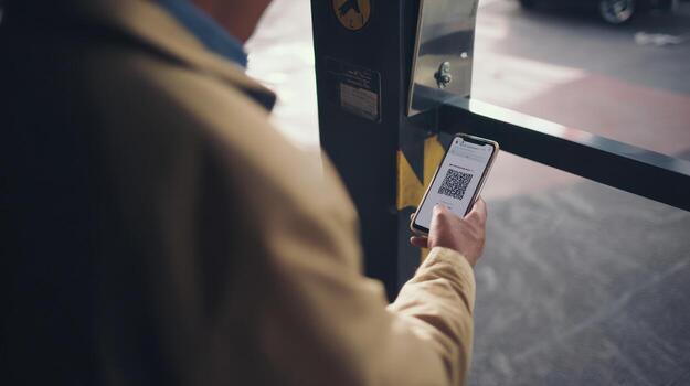 Man using smartphone to scan qr code at automated entry system photo