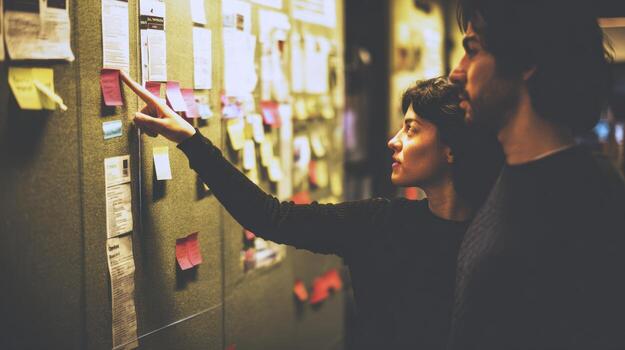 People reviewing documents on a wall analyzing information and data photo