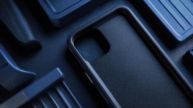 Close up of a dark phone case and related accessories on a dark surface photo