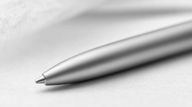 Close up of a silver pen on a white surface with soft focus photo