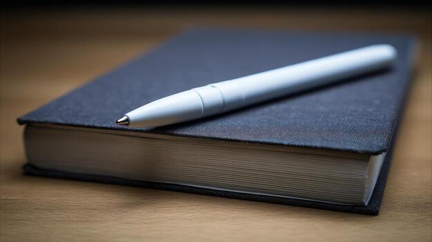 Notebook and pen resting on a wooden surface with soft focus and detail photo