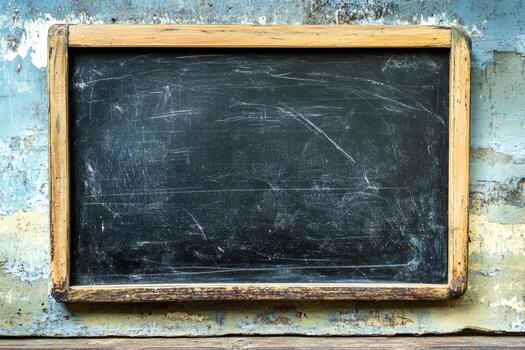 An empty black chalkboard sits against a weathered wall, ready for creative chalk drawings or educational lessons in a learning environment photo