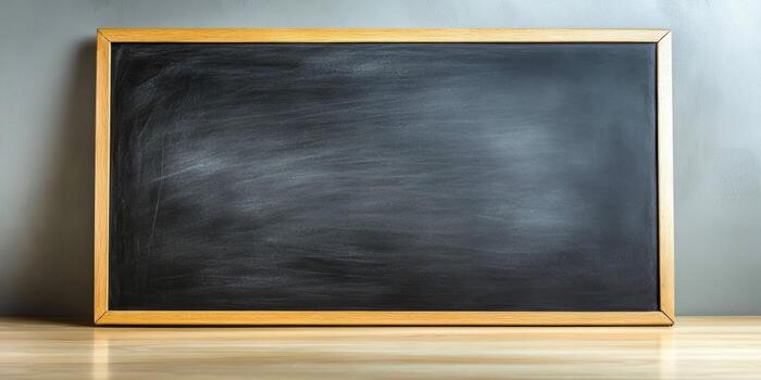Smooth black surface of a chalkboard framed in wood, ideal for teaching or presentations, located in a classroom environment photo