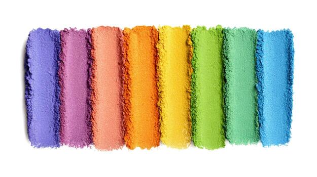 Colorful swatches of a rainbow gradient makeup palette are displayed on a white surface, showcasing various shades for creative makeup applications photo