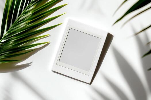 A stylish mockup features a blank Polaroid frame centered on a white background, surrounded by green palm leaves, perfect for showcasing memories photo