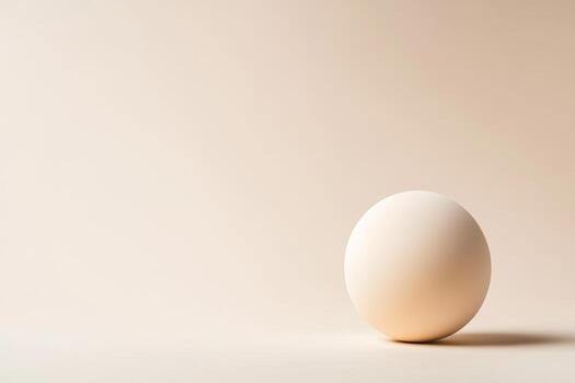 A single smooth sphere exhibits a subtle gradient while resting against a soft neutral backdrop, drawing attention to its simplicity and elegance photo