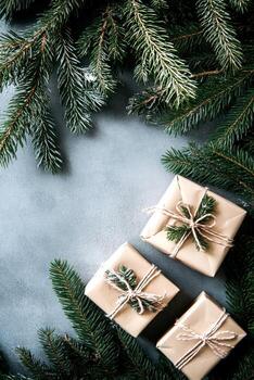 Festive gifts wrapped in plain paper are nestled among lush evergreen branches, creating a warm and inviting holiday atmosphere perfect for celebration photo