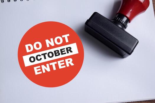 Concept of Do not enter October a red round sign write on book isolated on Wooden Table. photo