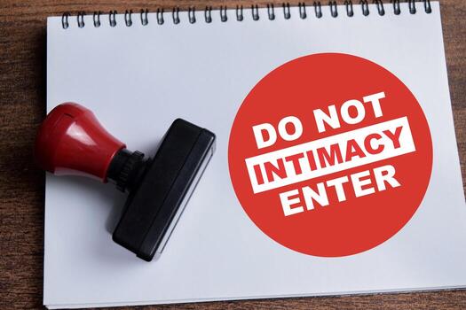 Concept of Do not enter intimacy a red round sign write on book isolated on Wooden Table. photo