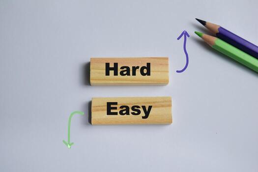 Hard and easy on stacked wooden cubes on the table. Symbolizing difficulty and life challenges. Business and finance concept photo
