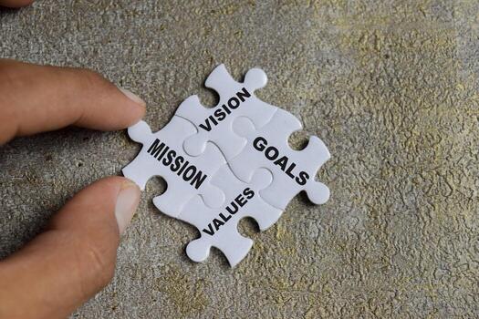 Piece of jigsaw puzzle with word Vision, Mission, Goals and Values the four pillars of success. Business and finance concept photo