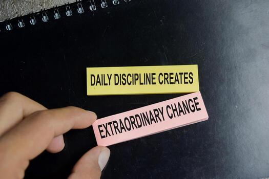 Concept of success daily discipline creates extraordinary change write on sticky notes isolated on Wooden Table. photo