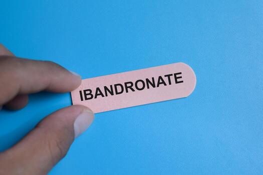Concept of ibandronate write on sticky notes isolated on Wooden Table. photo