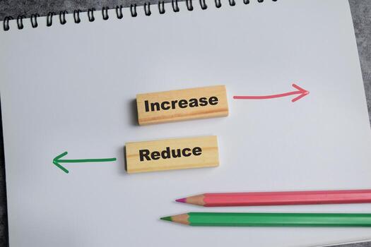 Concept of increase or reduce write on sticky notes isolated on Wooden Table. photo