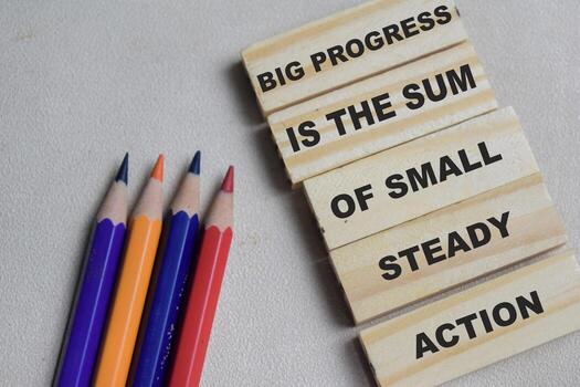 Big progress is the sum of small steady action on stacked wooden cubes on the table. Business and finance concept photo